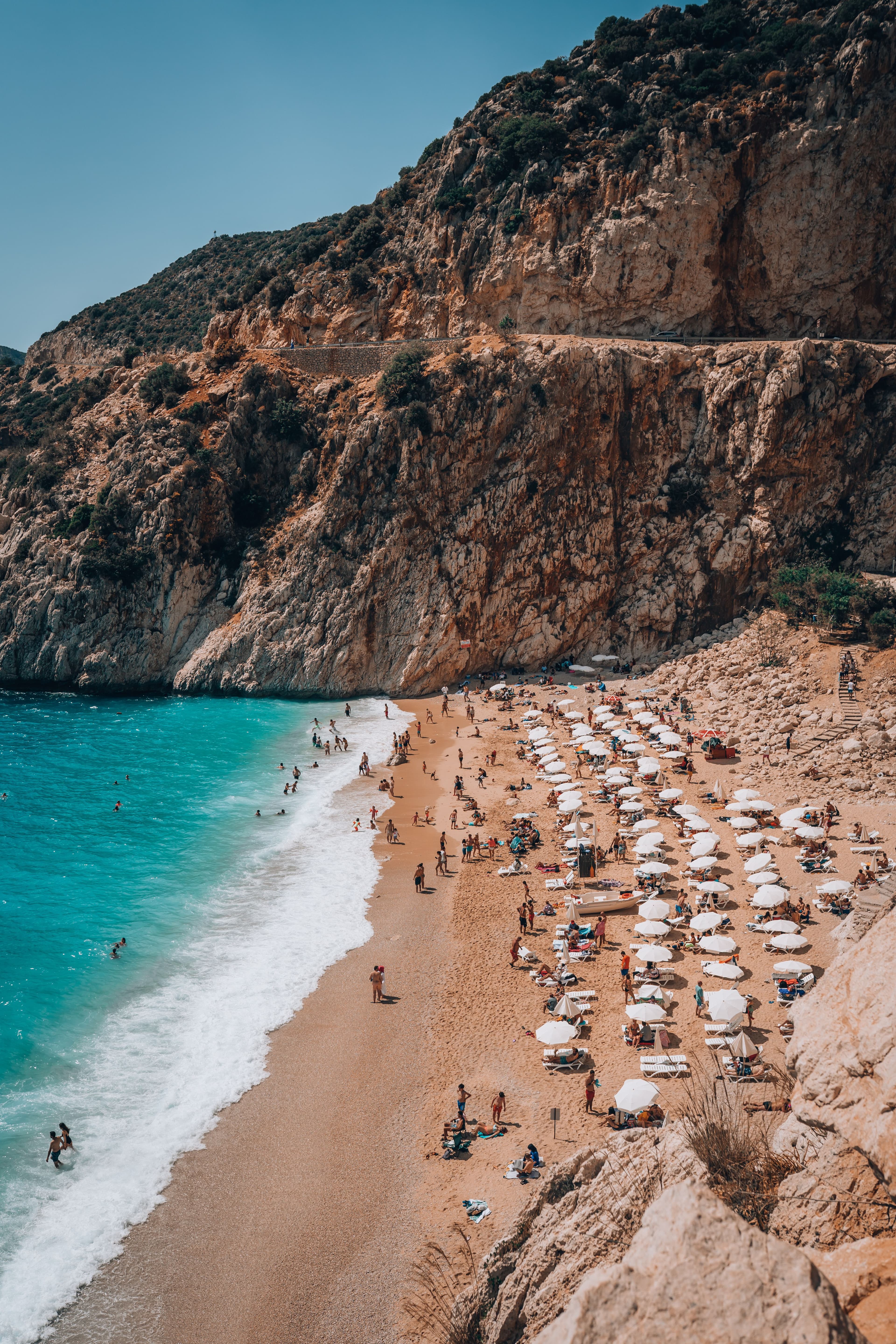 Kaputaş Beach seen from the clifftop, with the staircase down to the sand and turquoise water below