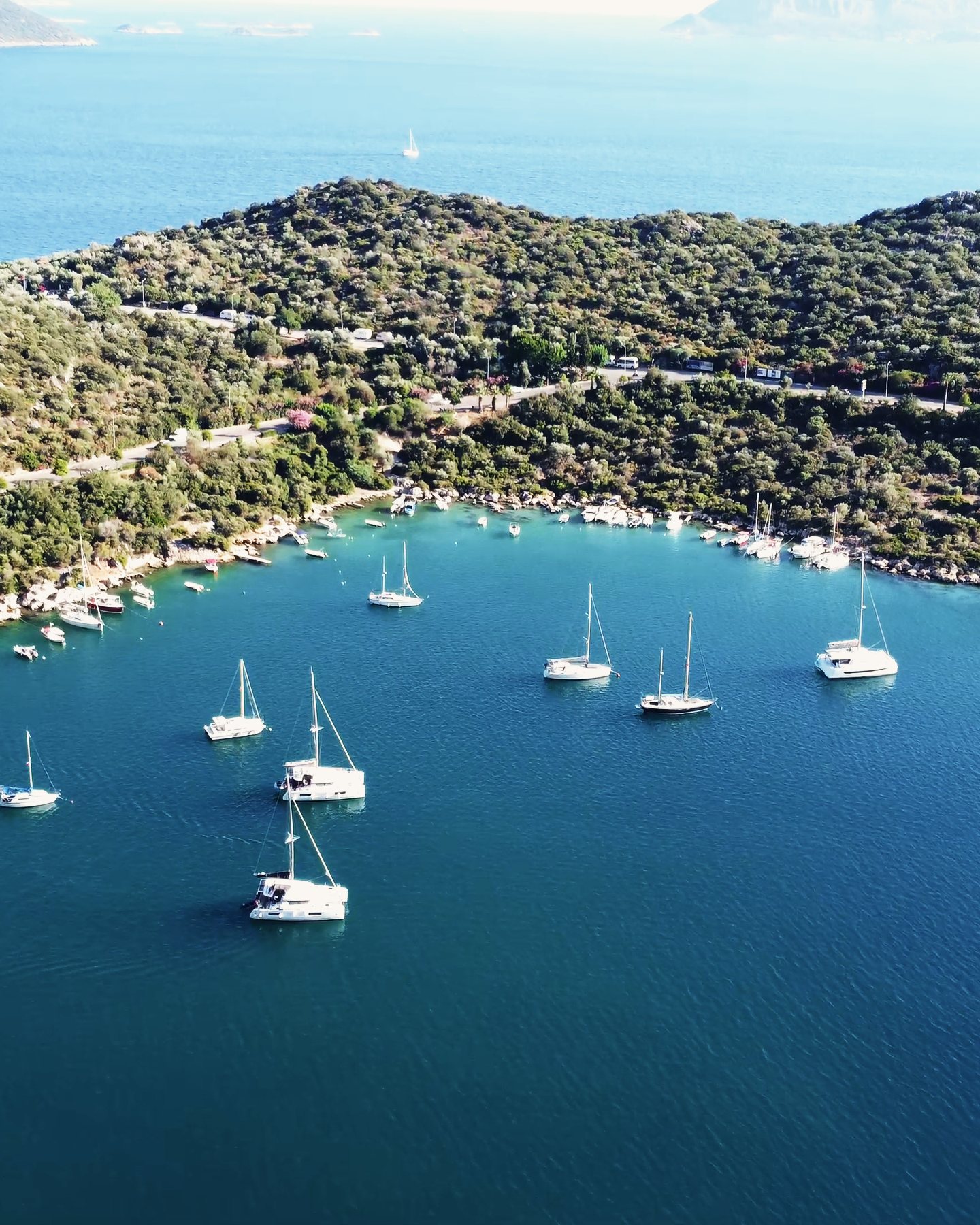 Yachts at anchor in a wide, clear bay